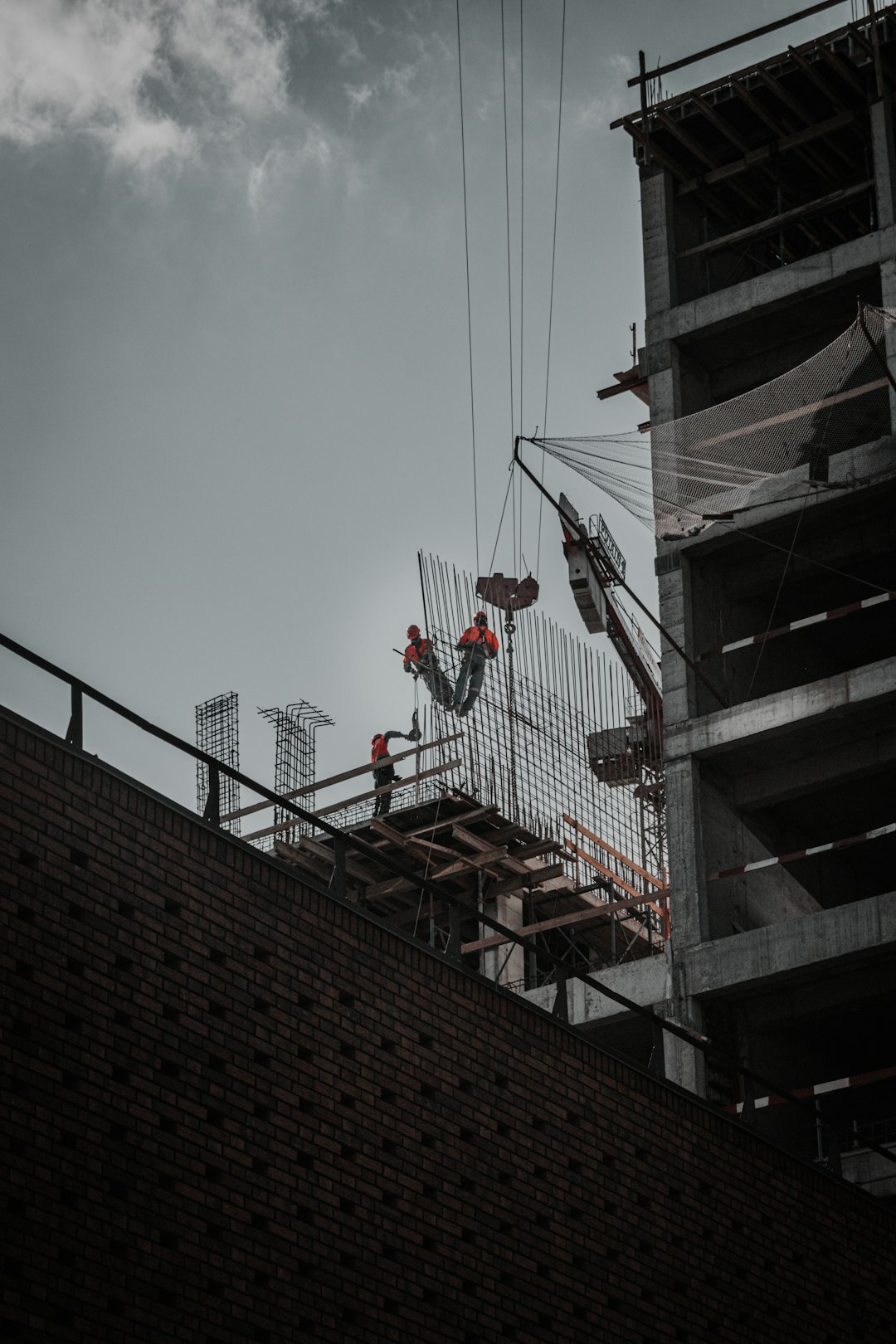 man in red jacket and black pants standing on top of building