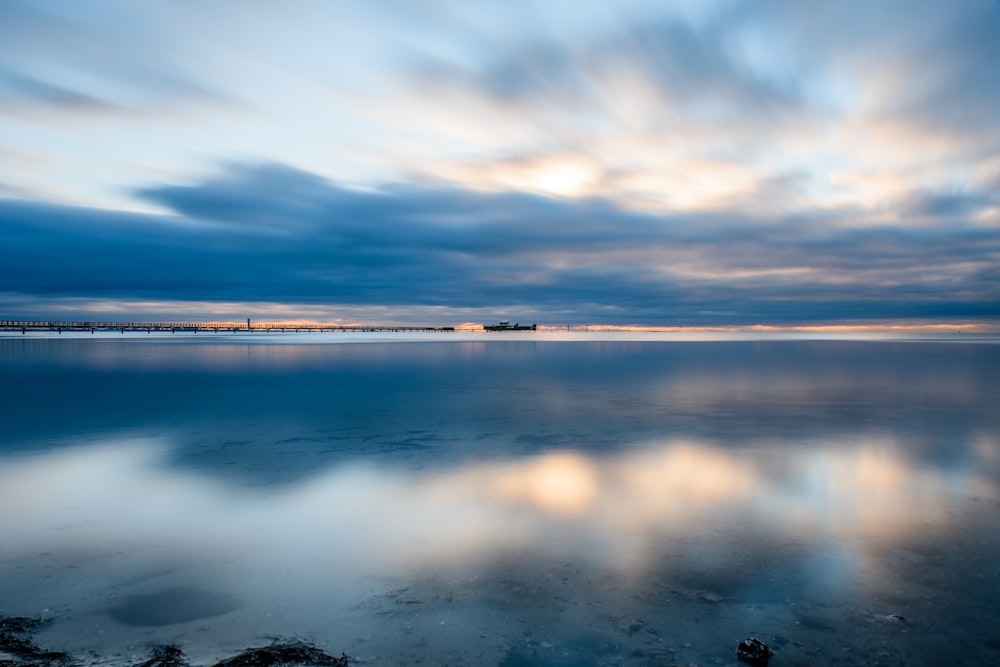 body of water under cloudy sky during daytime