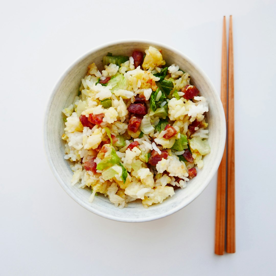 white ceramic bowl with food and brown chopsticks