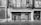 A black and white photograph of an old storefront with ornate architectural details. The facade features a balcony with iron railings, tiled designs, and a weathered sign that reads 'Azulejos Ramon Castello Pavimentos.' The entrance includes a decorative wall with a mural and a closed gate.