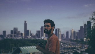 An influencer creating content outdoors with a scenic city skyline in the background.