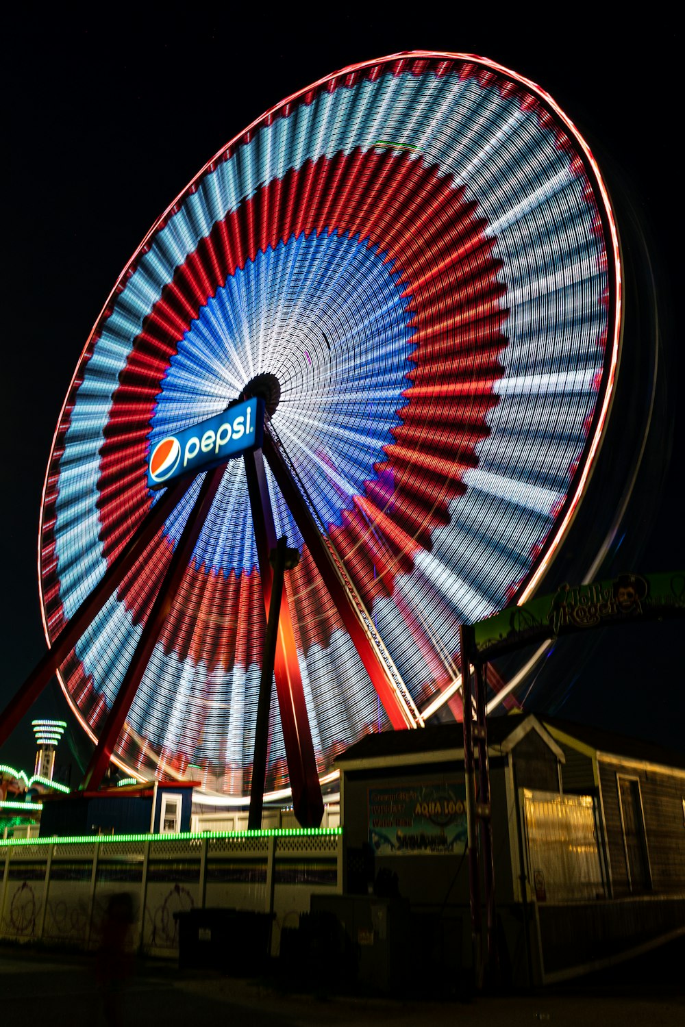 Rueda de la fortuna azul, roja y blanca durante la noche