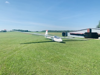 A custom hangar home nestled beside a private airstrip under a clear blue sky.