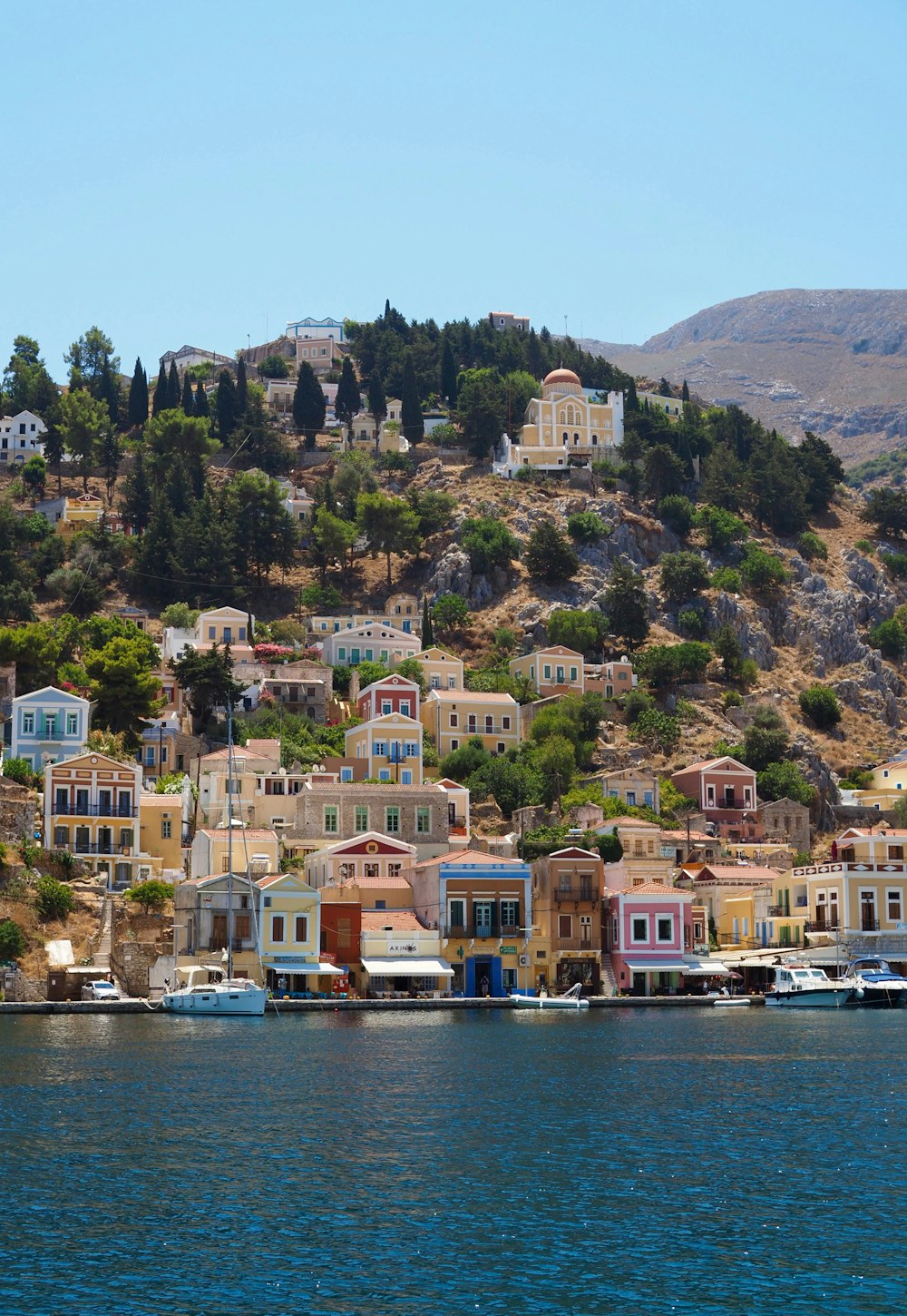 houses on mountain near body of water during daytime