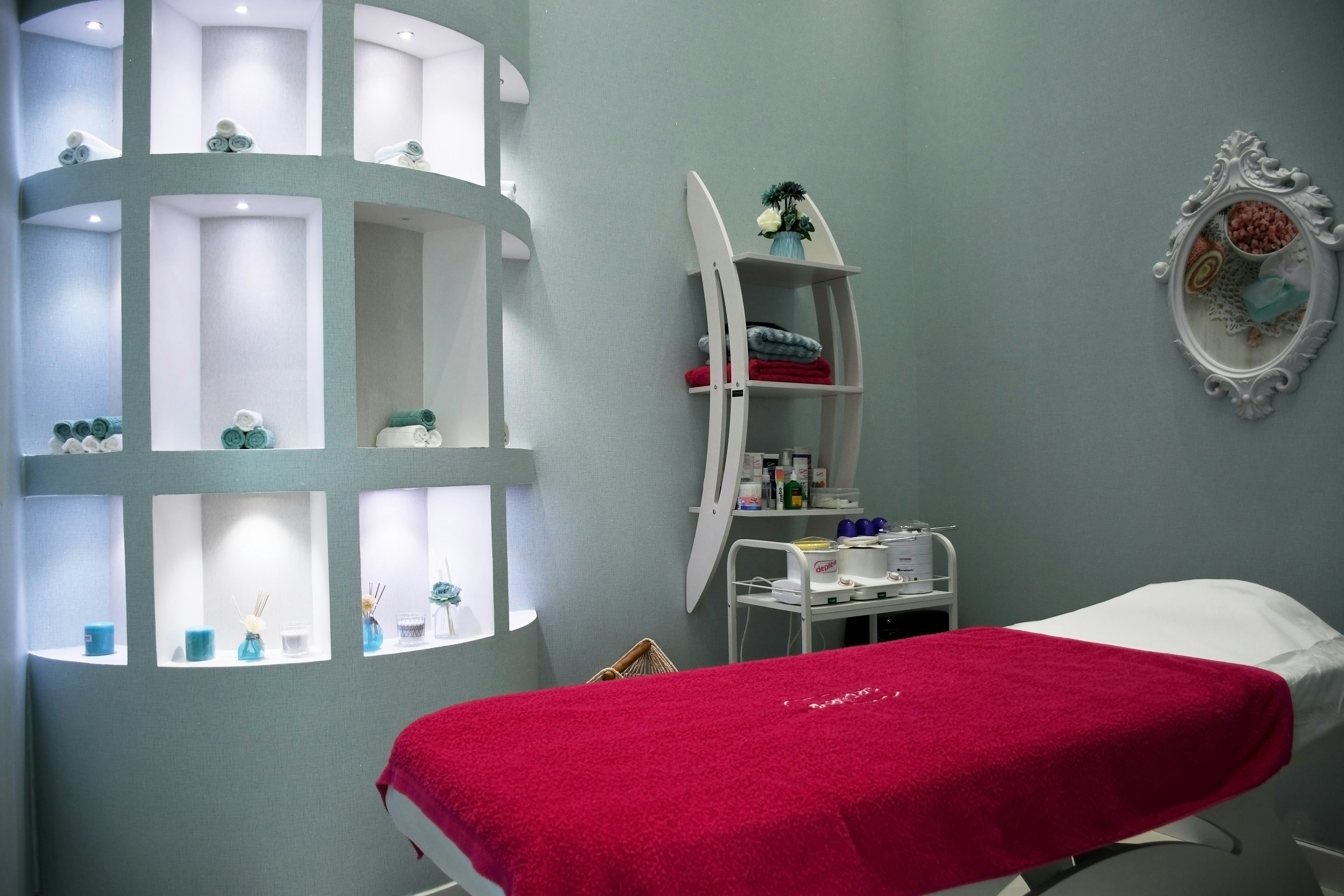Spa treatment room with warm towels and waxing supplies on wooden table