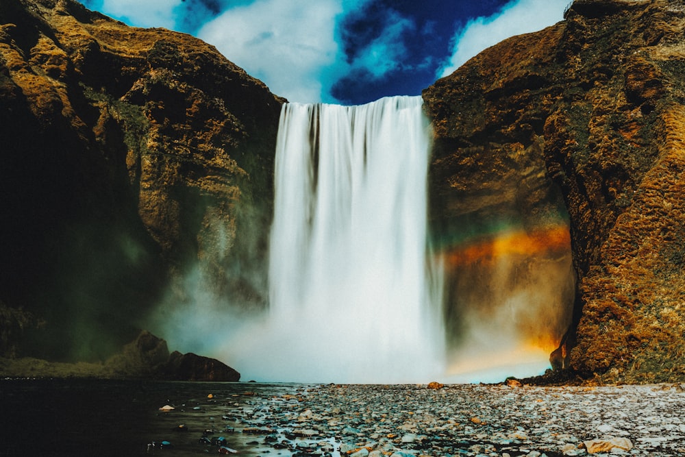 waterfalls on rocky shore during daytime