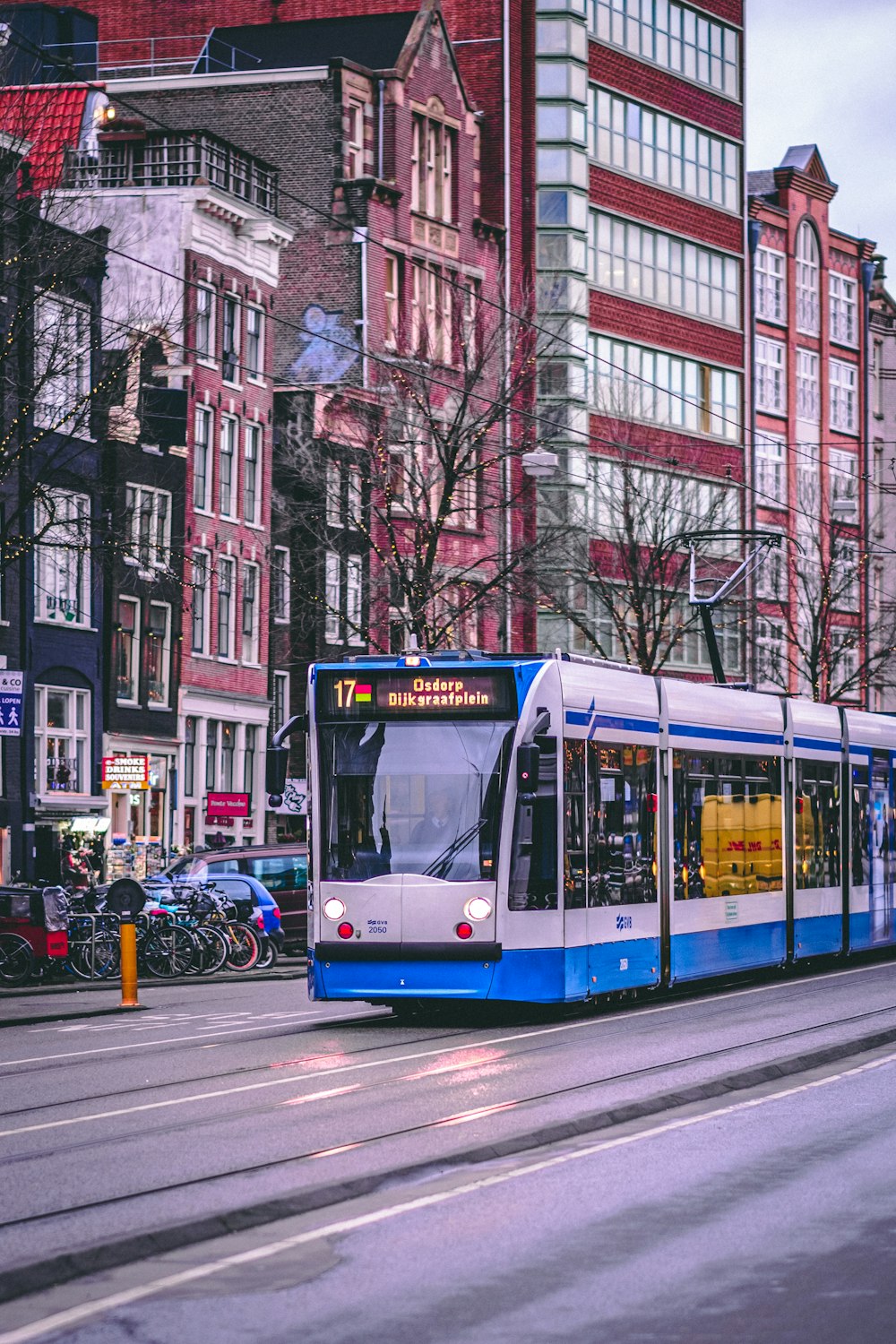 blue and white tram on road near building during daytime