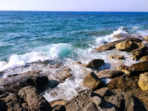 Crystal clear ocean waves crashing against a rocky shore.