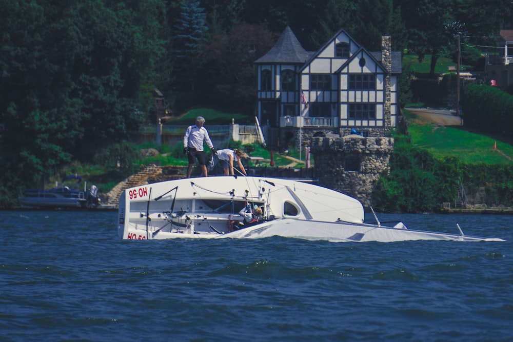 man in white shirt riding white boat on water during daytime