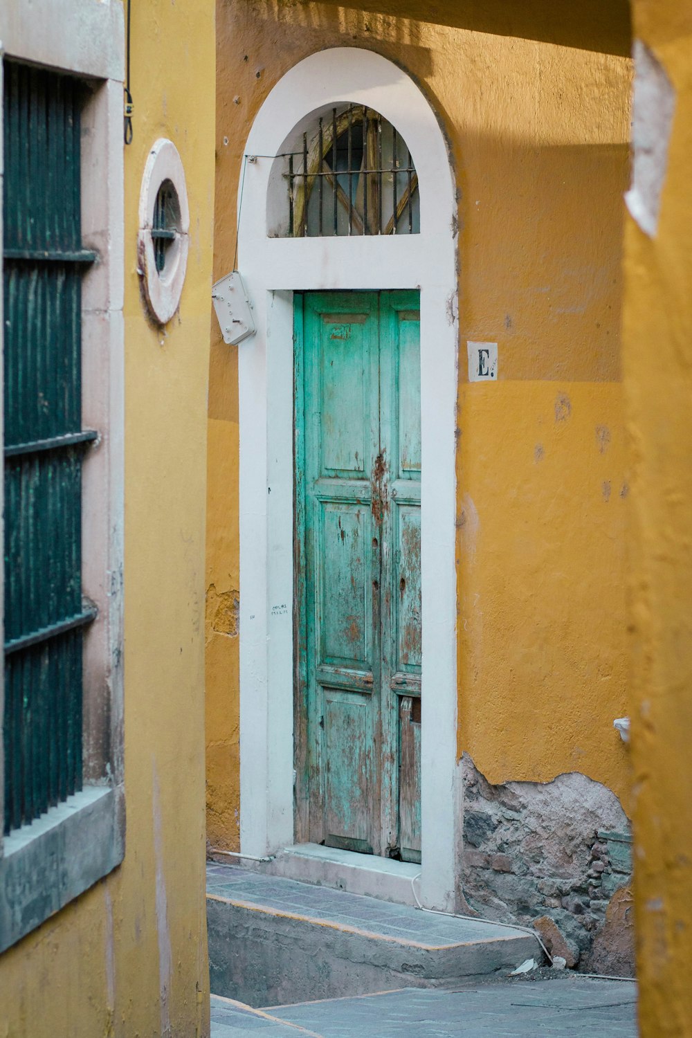 blue wooden door on yellow concrete building