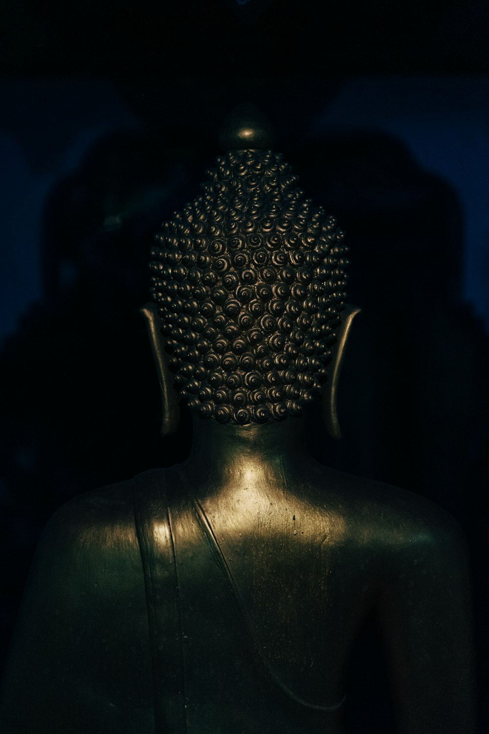 Estatua de Buda de plata en cuarto oscuro