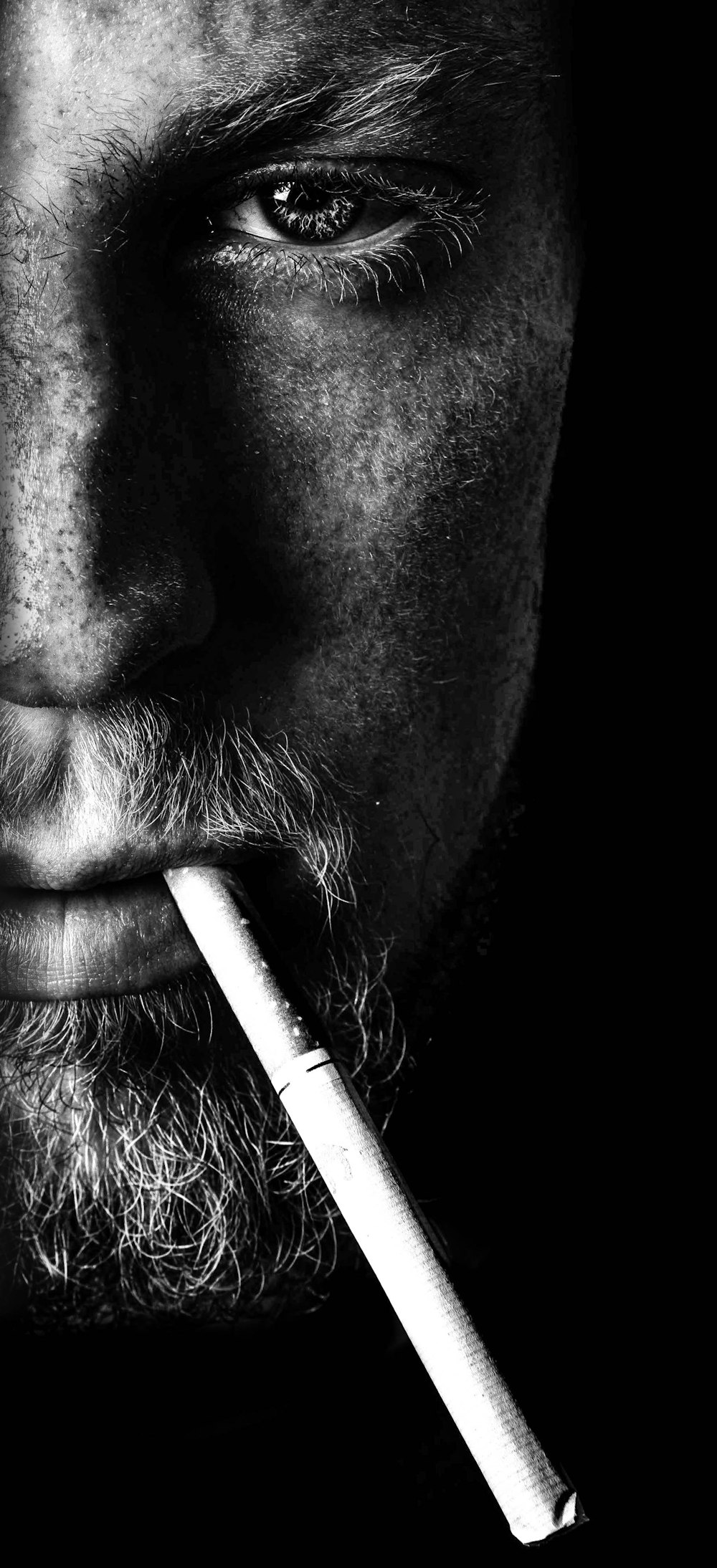 man smoking cigarette in grayscale photography