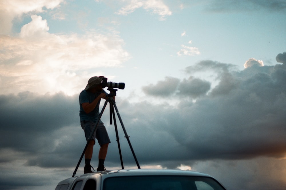 man in gray shirt and gray pants taking photo of clouds