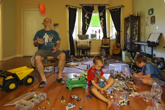 A cheerful family playing with colorful toys in a bright living room