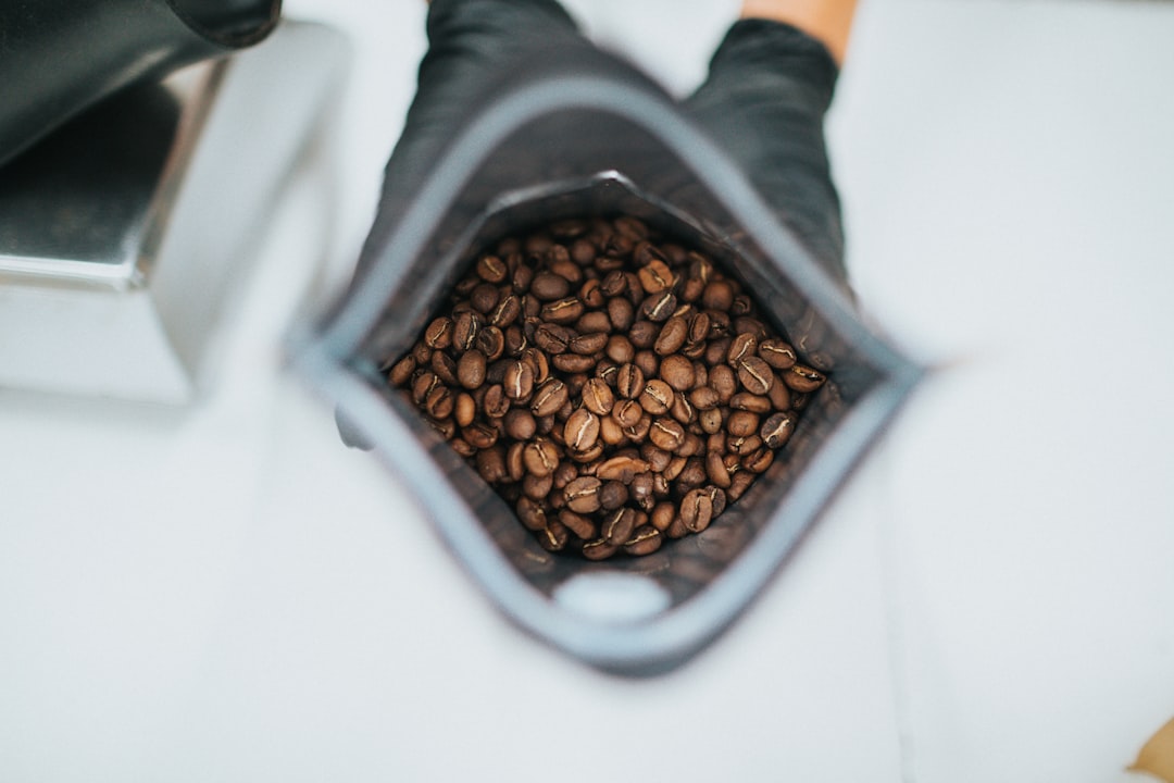 brown coffee beans in gray plastic container