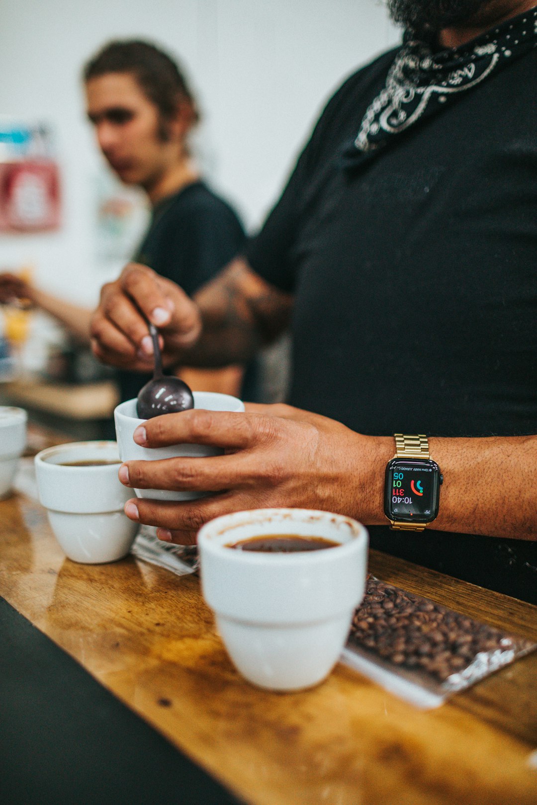 man in black shirt holding white ceramic teacup