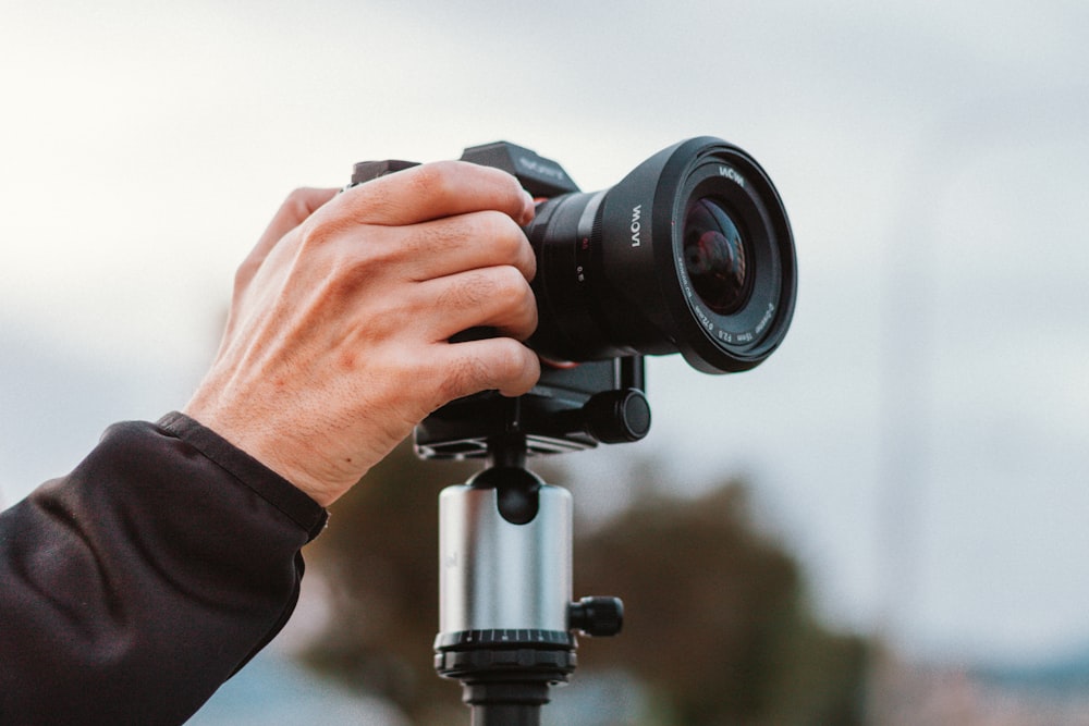 person holding black dslr camera