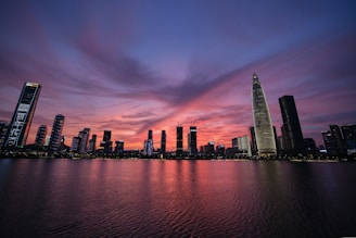 high rise building near body of water during sunset