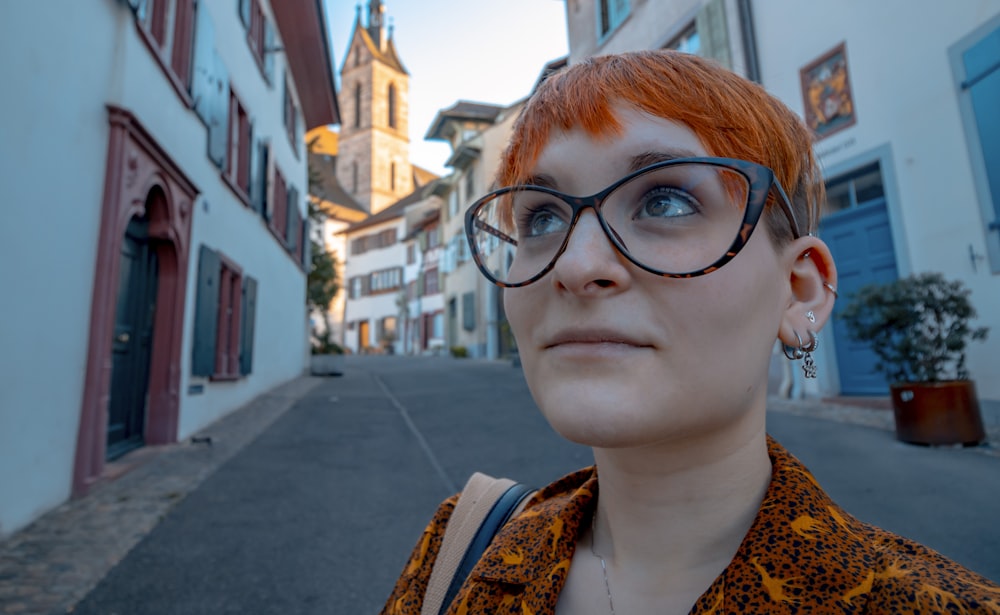 a woman with red hair wearing a pair of glasses