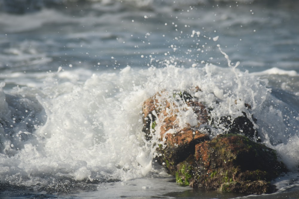 water waves hitting rocks during daytime