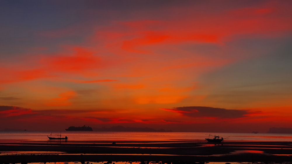 Boot auf See unter orangefarbenem und blauem Himmel