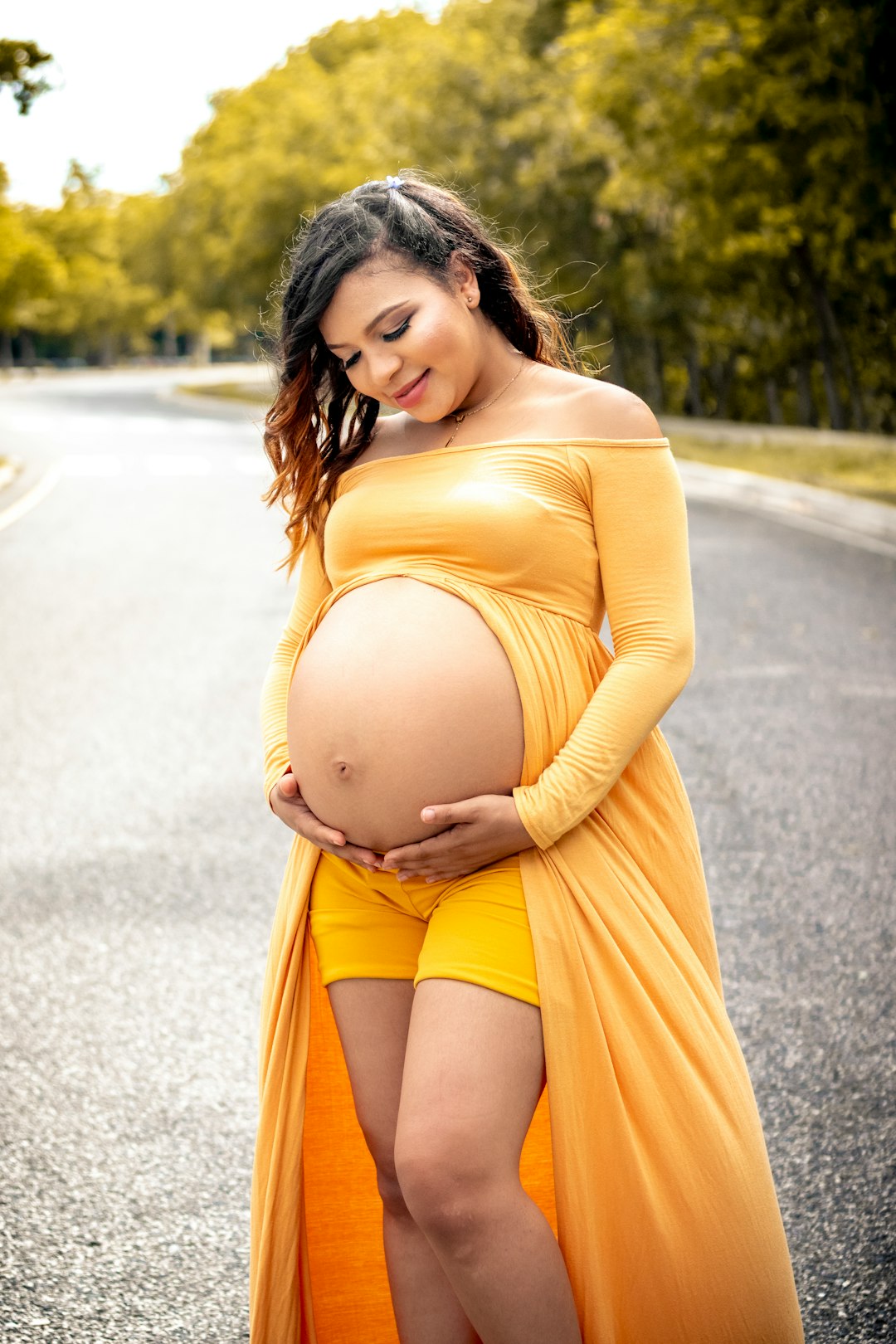 woman in yellow long sleeve dress standing on road during daytime