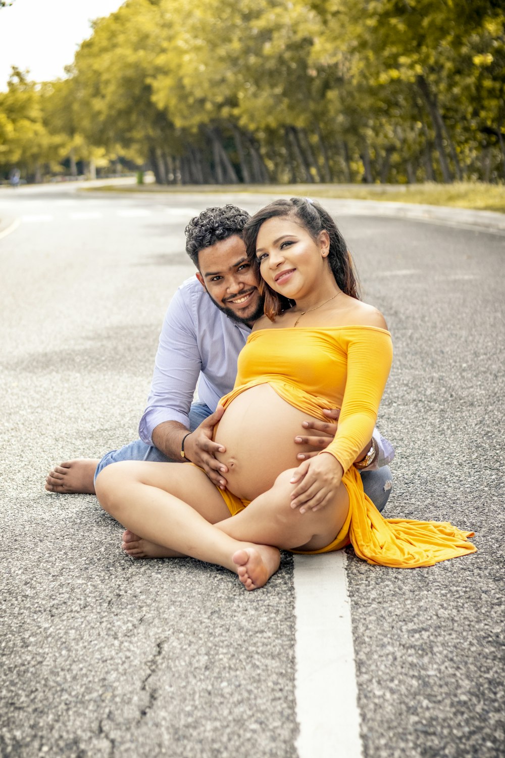 woman in yellow tank top sitting on man in white dress shirt on gray asphalt road