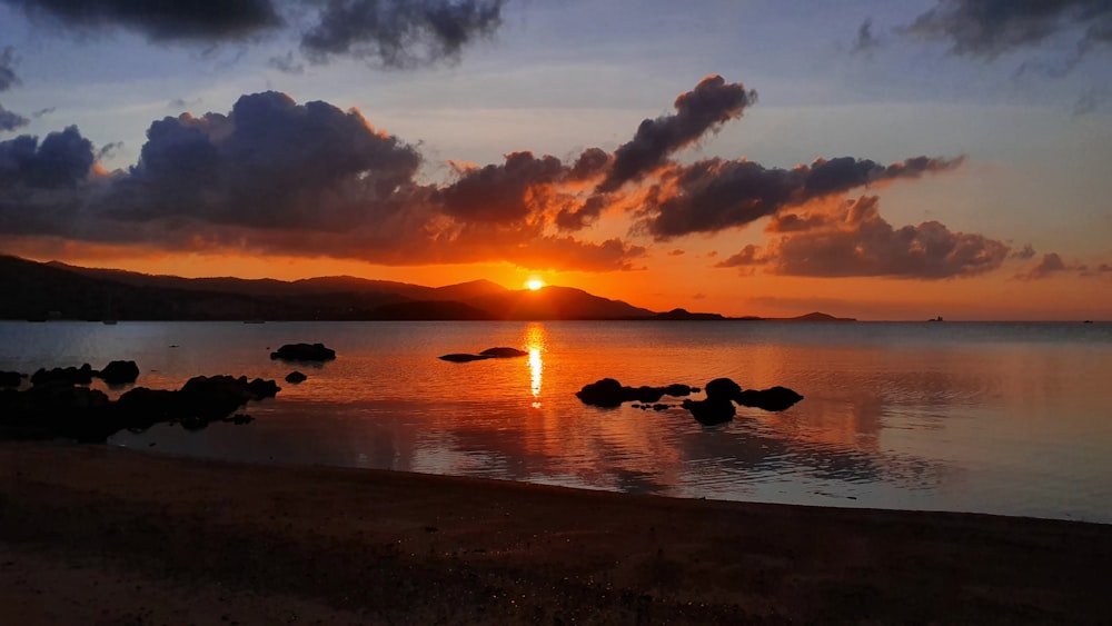 silhouette de rochers sur le rivage de la mer au coucher du soleil