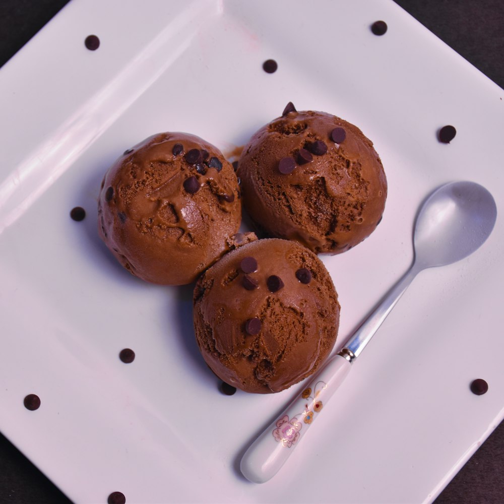 three chocolate chip cookies on white ceramic plate