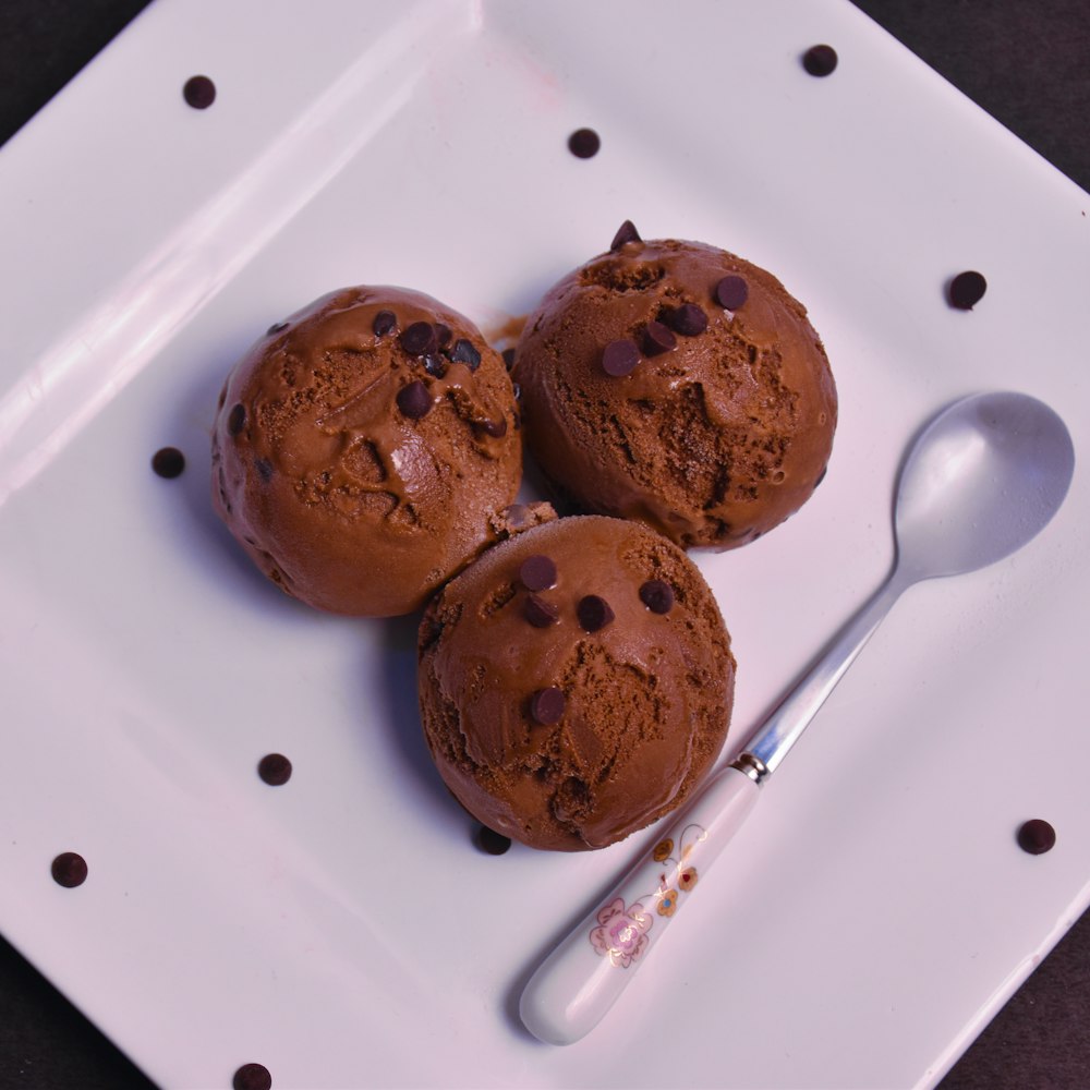 Trois biscuits aux pépites de chocolat sur une assiette en céramique blanche