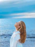 woman in white shirt standing near sea during daytime