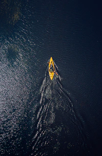 yellow and black surfboard on body of water