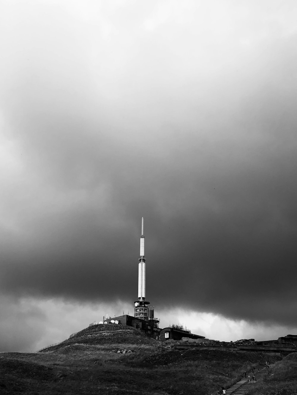 grayscale photo of building under cloudy sky