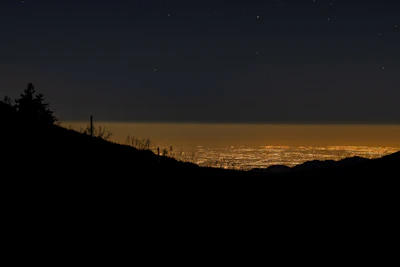 Night view of Monterrey skyline illuminated with city lights and mountain silhouettes.