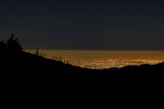 Night view of Monterrey skyline illuminated with city lights and mountain silhouettes.