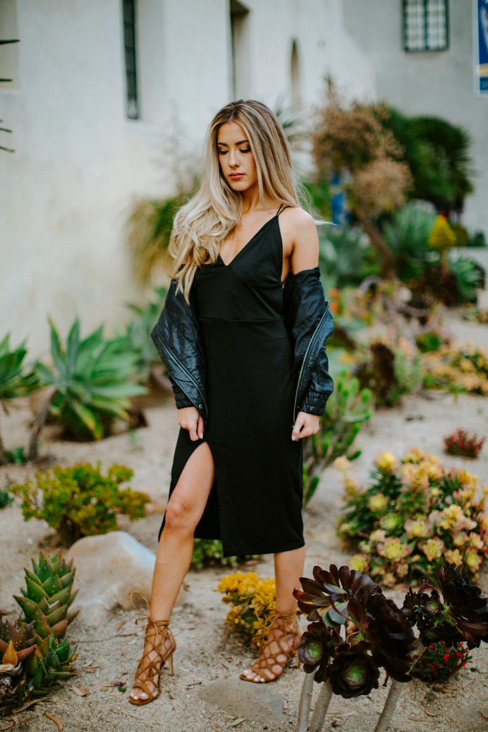 woman in black off shoulder dress standing on brown dried leaves during daytime