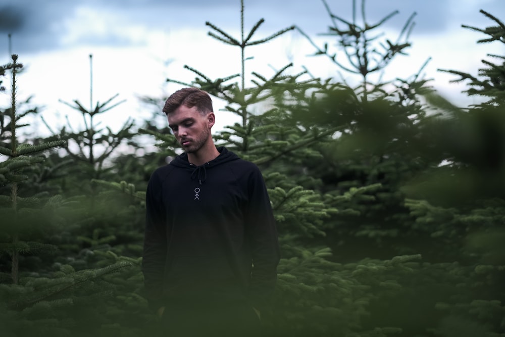 man in black jacket standing on green grass field during daytime