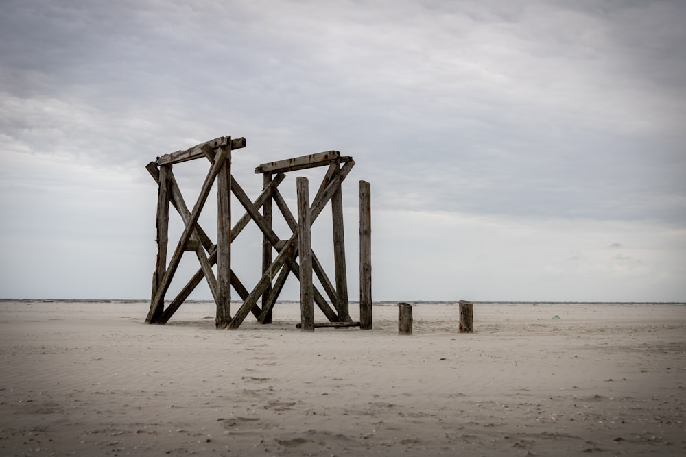 brown wooden posts on brown sand during daytime