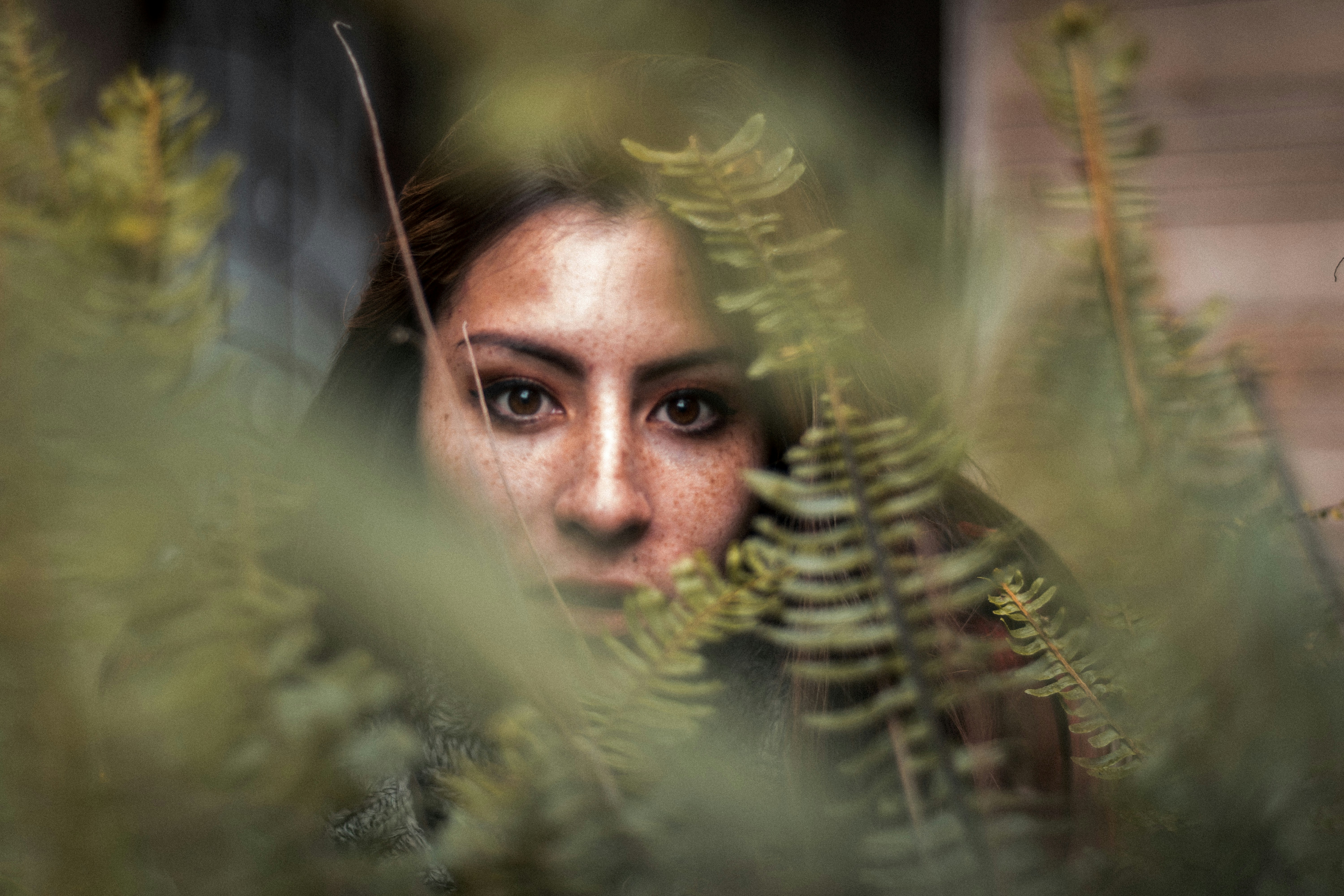 mans face surrounded by green plants