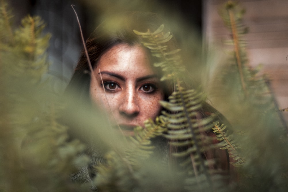 mans face surrounded by green plants