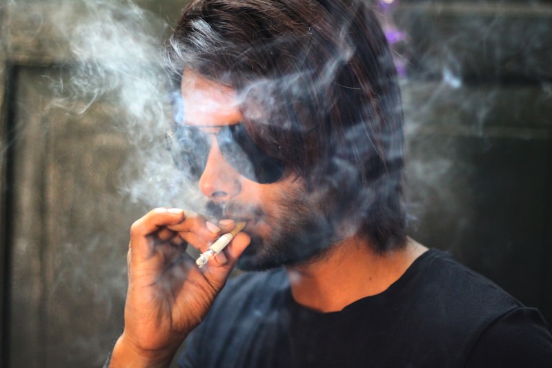 gay man in black shirt smoking