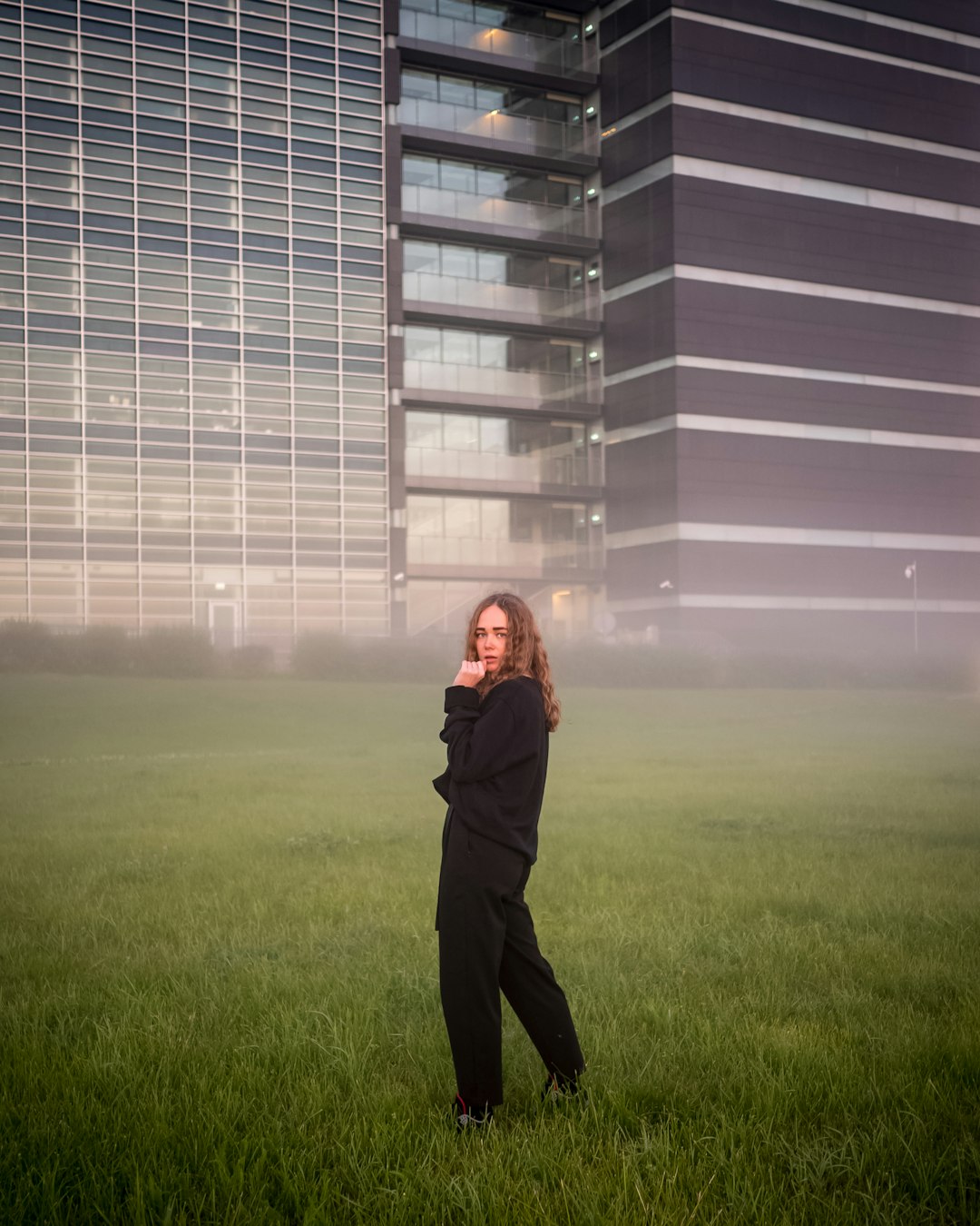 woman in black jacket standing on green grass field