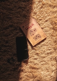 A diverse group of people reading Arabic books on digital devices in a cozy setting.