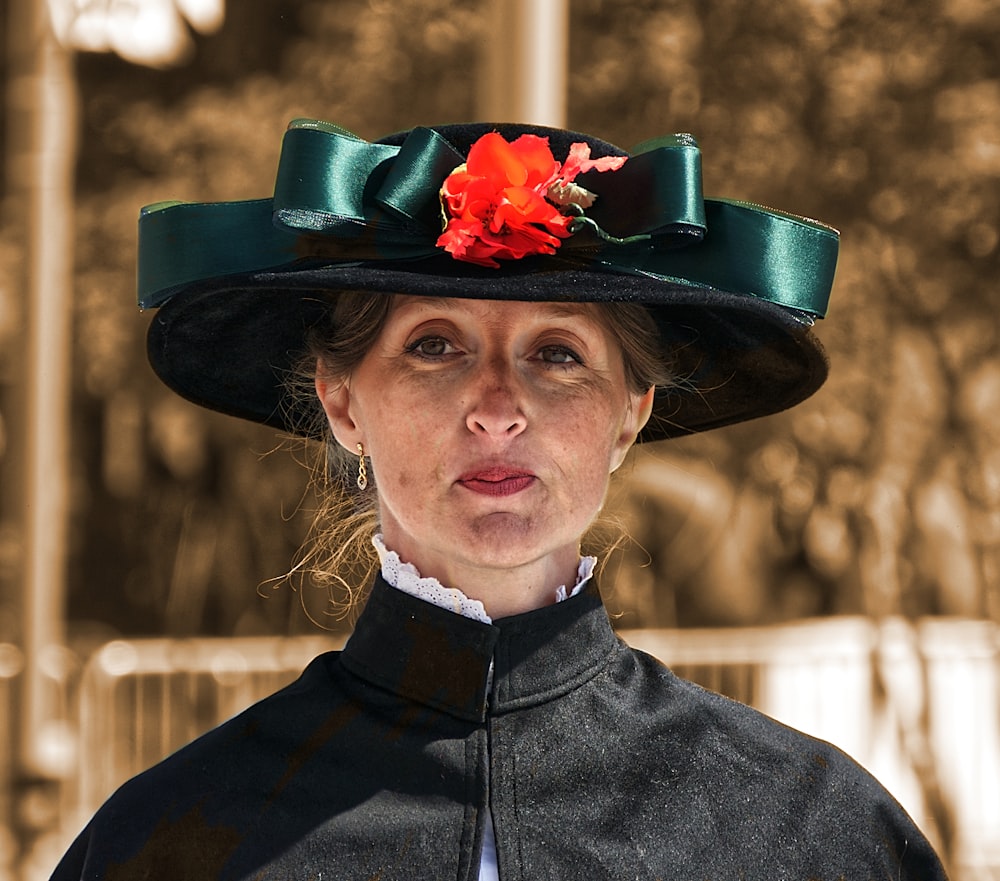 woman in black hat with red flower on head