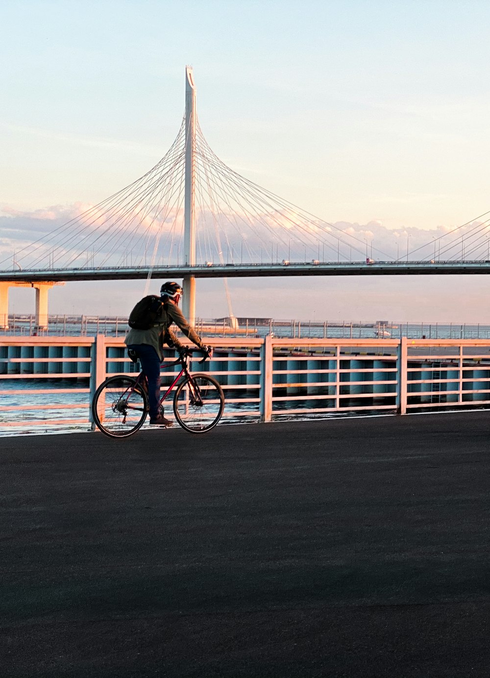 man in black shirt riding bicycle on bridge during daytime