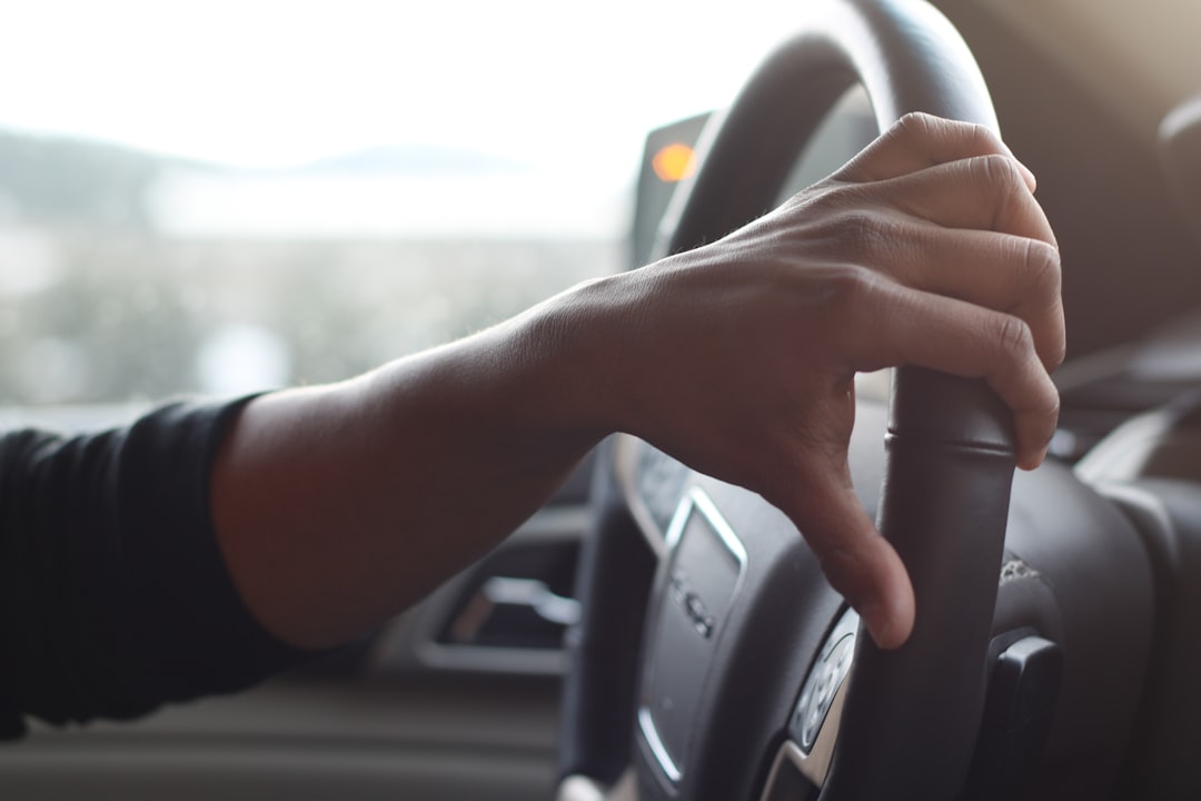 person holding black car steering wheel,