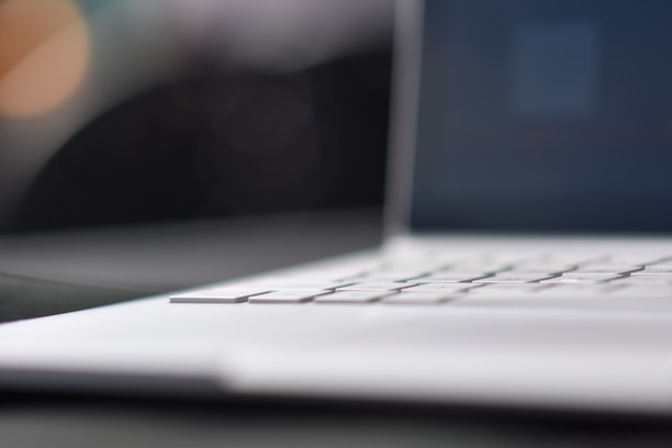 Close-up of hands typing on a sleek keyboard with a digital innovation concept on screen.