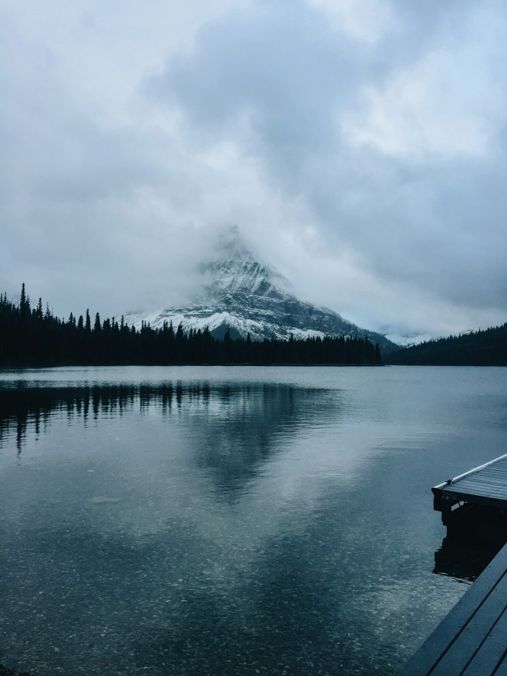 a boat is docked on a lake with a mountain in the background