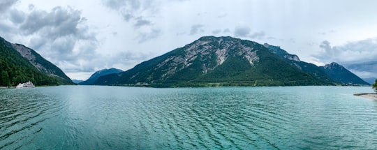 green mountain beside body of water during daytime in Pertisau Austria