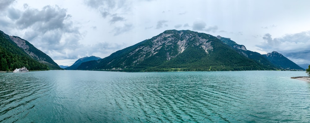 green mountain beside body of water during daytime